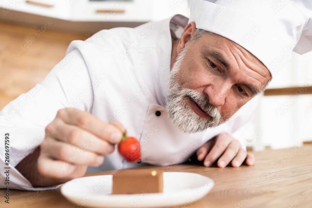 Poster Close up pastry chef decoration delicious dessert dish, serving for customers in bakery, garnishing dessert plate in commercial kitchen.