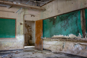 Fototapeta na wymiar Two green chalkboards abandoned in a long forgotten school