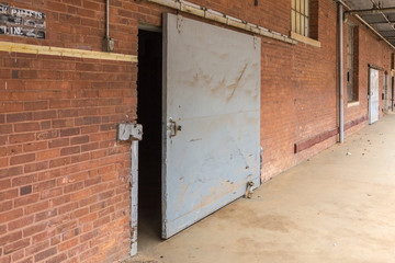 Large metal barn door on rollers at an abandoned brick factory