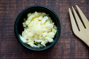 Finely chopped garlic in black bowl