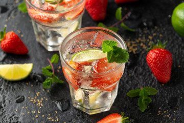Strawberry Mojito cocktail with Rum, lime and mint in glass. Summer cold drink with ice