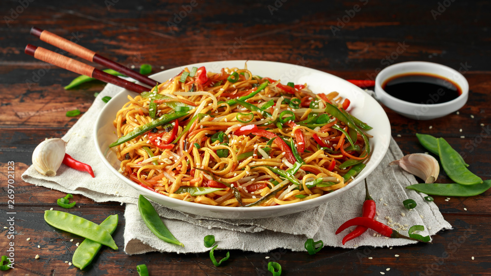 Wall mural chow mein, noodles and vegetables dish with wooden chopsticks