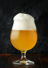 Glass of chilled unfiltered beer with on wooden table