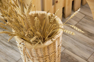 rustic tema. ears of wheat stand in a wicker basket.