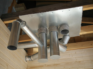 Whole house air ventilation and cleaning system. Ventilation metal pipes in silver insulation material and roof ferm.