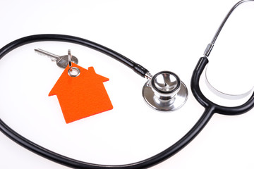 Stethoscope and house with key isolated on white background. Healthcare and Insurance concept