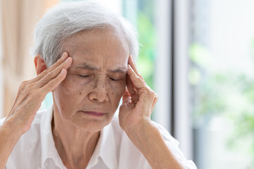 Asian senior woman has headache,touching her head with her hands,communicates the symptoms of vertigo;dizziness;migraine;sick depressed,elderly people suffering from headache pain and feeling unwell