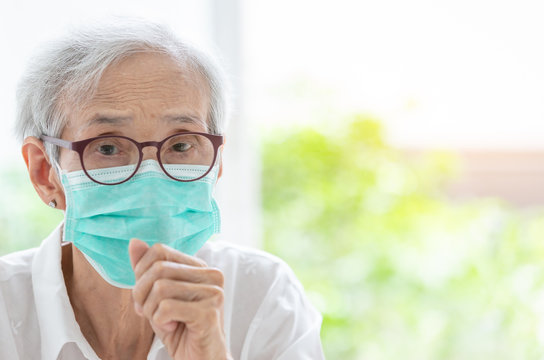 Asian senior woman suffer from cough with face mask protection,elderly woman wearing face mask because of air pollution,Sick old people with medical mask;concept of pollution,dust allergies and health