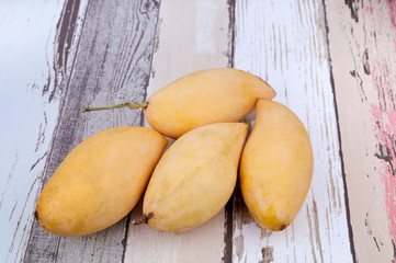 Fresh mango fruits over wooden textured background