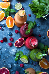 Colorful detox smoothie in bottles, summer diet fresh drink, red, green, yellow smoothie with berries and fruits