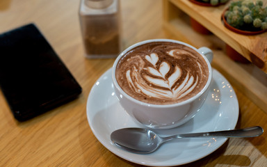 cup of coffee with whipped cream on wooden background