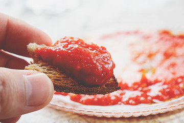 Roasted Bread, Tomato Sauce Close Up on a Kitchen Table, man hand