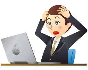 ノートパソコンを見て驚くビジネスマン