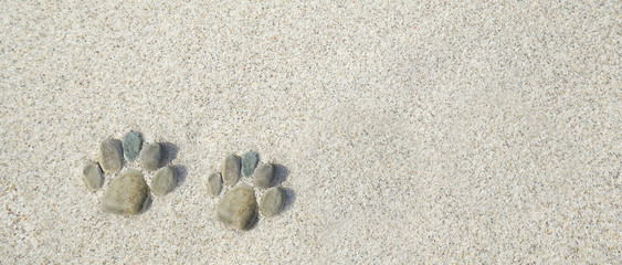 kleine Füsse aus Steinen im Sand