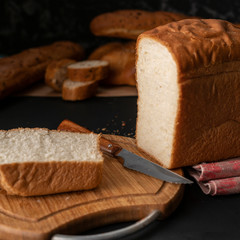 freshly baked sliced white bread with metal knife, toasts for cooking sandwitchs