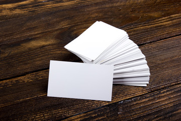 Blank business cards on the wooden table. Template for ID. Top view. Office desk tabl.