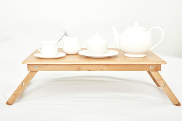 breakfast in the room on the table is on a white bed
