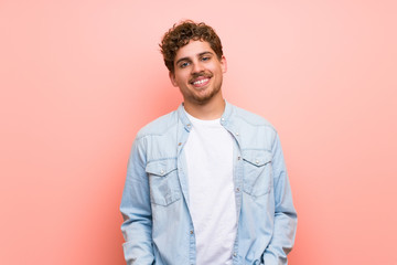 Fototapeta premium Blonde man over pink wall With happy expression