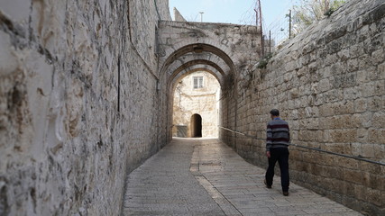 Fototapeta na wymiar Man walking on the street of old Jerusalem in Israel.