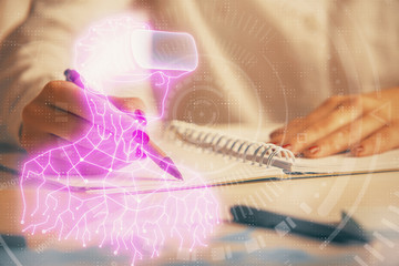 Fototapeta premium AR hologram over hands taking notes background. Concept of augmented reality. Double exposure
