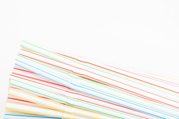 A bunch of single-use disposable colored bendy plastic straw set on a plain white background.