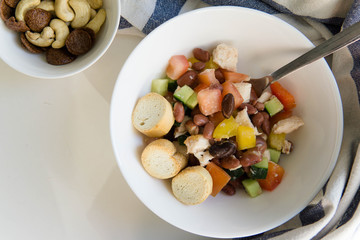 Summer salad with beans, tomatoes, cucumber, pepper and chicken dressed with olive oil