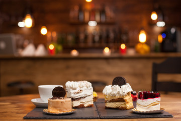 Different cakes with pudding cream on wooden table in a coffee shop