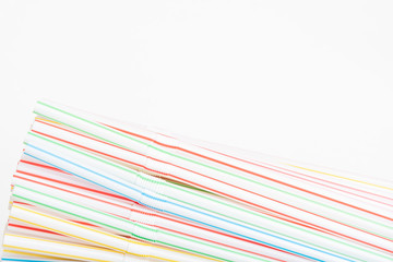 A bunch of single-use disposable colored bendy plastic straw set on a plain white background.