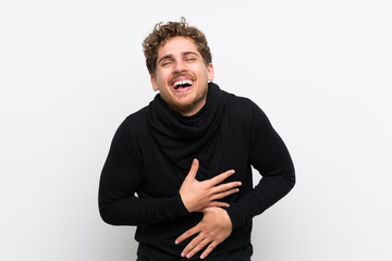 Blonde man over isolated white wall smiling a lot