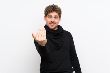 Fototapeta premium Blonde man over isolated white wall inviting to come with hand. Happy that you came