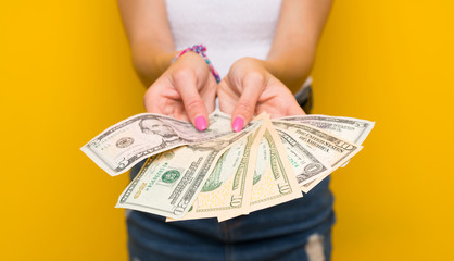 Young blonde woman over isolated yellow wall taking a lot of money