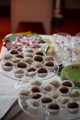 small cakes, sprinkled with ground nuts and cocoa, in paper tins on a glass plate