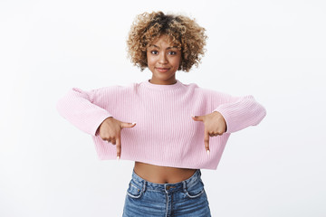 Confident and charismatic attractive african-american slim girl with fair haircut pointing down...