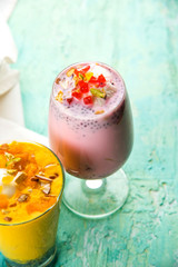 Falooda / Faluda is a popular Indian dessert - Strawberry and Mango flavoured which has Ice cream, noodles, sweet basil seeds and nuts, selective focus