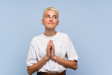 Teenager girl with white short hair over blue wall scheming something