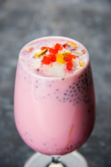 Falooda / Faluda is a popular Indian dessert - Strawberry and Mango flavoured which has Ice cream, noodles, sweet basil seeds and nuts, selective focus
