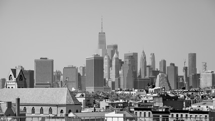 Fototapeta na wymiar Black and white picture of Manhattan seen from the Brooklyn neighborhood on a hazy summer day, USA.