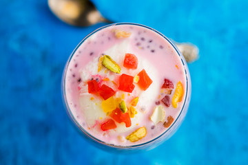 Falooda / Faluda is a popular Indian dessert - Strawberry and Mango flavoured which has Ice cream, noodles, sweet basil seeds and nuts, selective focus