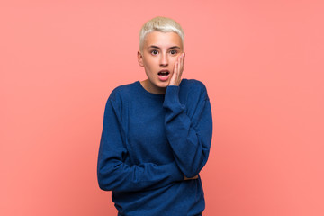 Teenager girl with white short hair over pink wall surprised and shocked while looking right