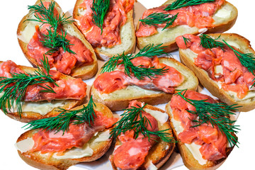 Sandwiches with salmon and cheese in a plate on a white background