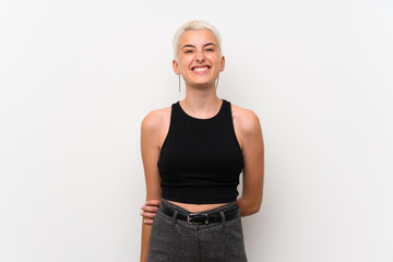 Teenager girl with short hair over white wall laughing