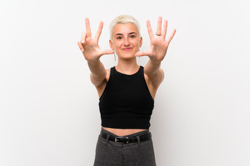 Teenager girl with short hair over white wall counting eight with fingers