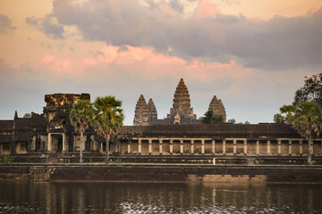 Angkor Wat dramatic sky at dawn main facade silhouette reflection on water pond. World famous temple in Cambodia.