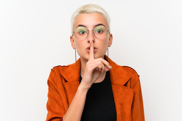 Teenager girl with short hair over white wall doing silence gesture