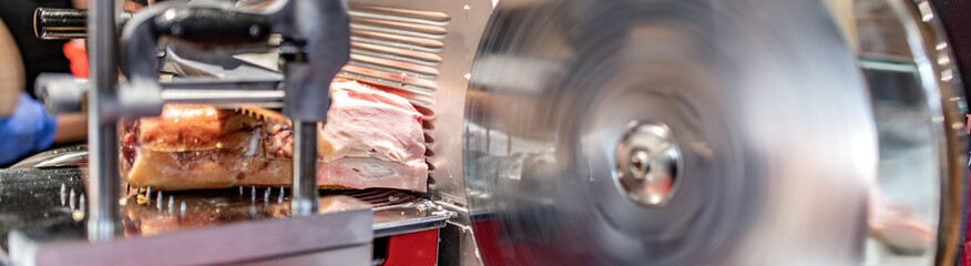 Affettatrice con prosciutto crudo e lama in vista per negozio di gastronomia