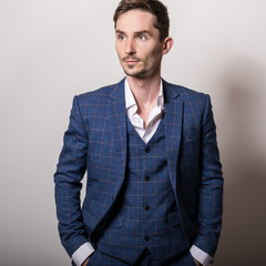 Elegant young handsome man in stylish blue costume. Studio fashion portrait.