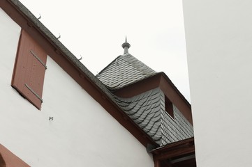 View of a medieval building with a white wall and a red window (Germany, Europe)