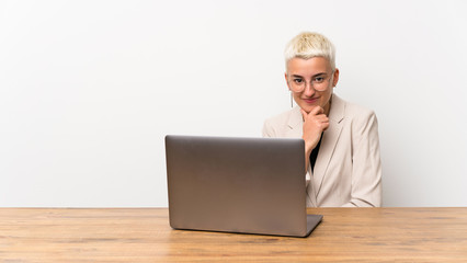 Teenager girl with short hair with a laptop looking to the side