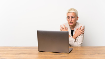 Teenager girl with short hair with a laptop freezing