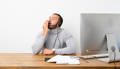 Telemarketer Colombian man yawning and covering wide open mouth with hand